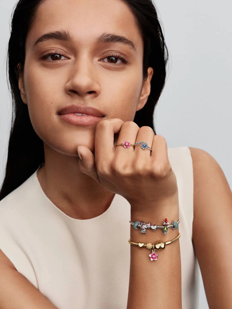 Disney Moana Blomma Ring Guld från Pandora med rosa emaljblomma och gnistrande sten på guldpläterad yta.