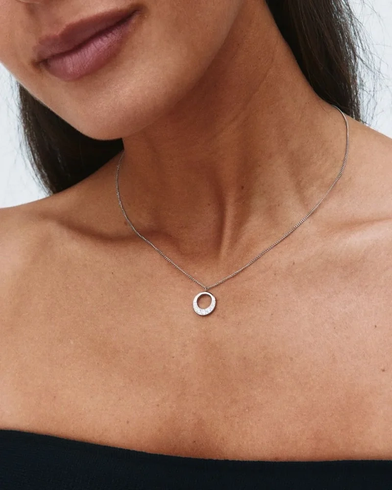 Halsband i polerat stål med runt hänge dekorerat med skimrande cubic zirconia-stenar från Edblads Monarch-kollektion.