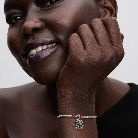 Julkrans Hängberlock från Pandora. Smyckad med gröna kristaller och röd emalj för en lekfull julstil. Lys upp dina festkläder med glamour och sprid julstämning vart du än går.