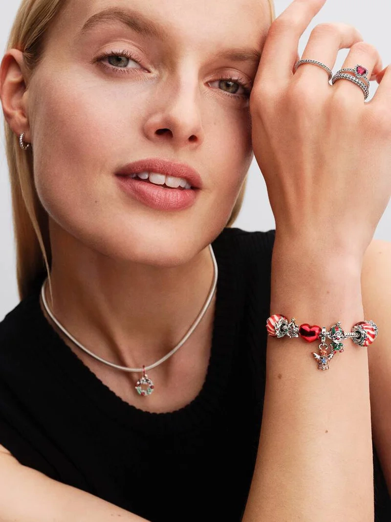 Julkrans Hängberlock från Pandora. Smyckad med gröna kristaller och röd emalj för en lekfull julstil. Lys upp dina festkläder med glamour och sprid julstämning vart du än går.