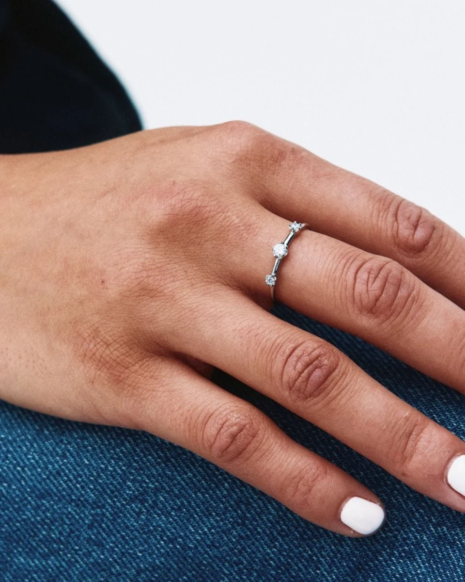 Guldfärgad ring i polerat stål med små gnistrande cubic zirconia-stenar