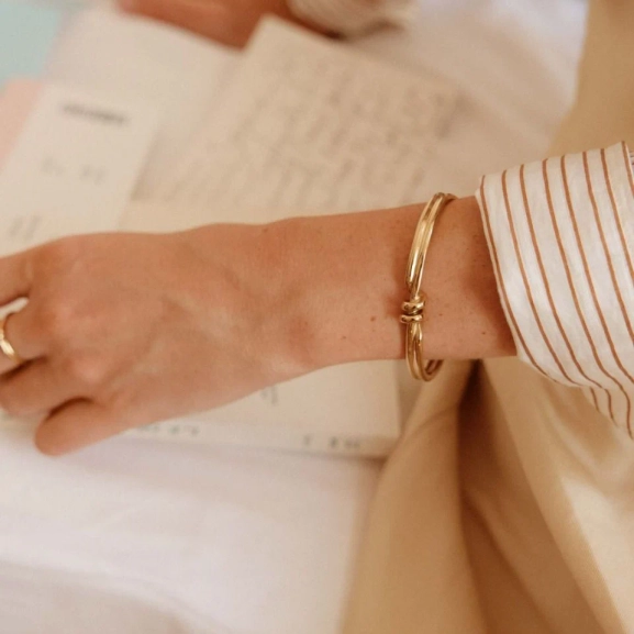 Guldpläterad bangle med spiralform och oval pärlemorpärla från Edblads Swivel-kollektion