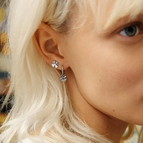 Örhängen i polerat rostfritt stål med stilren ring och avtagbart hänge format som en fyrklöver.