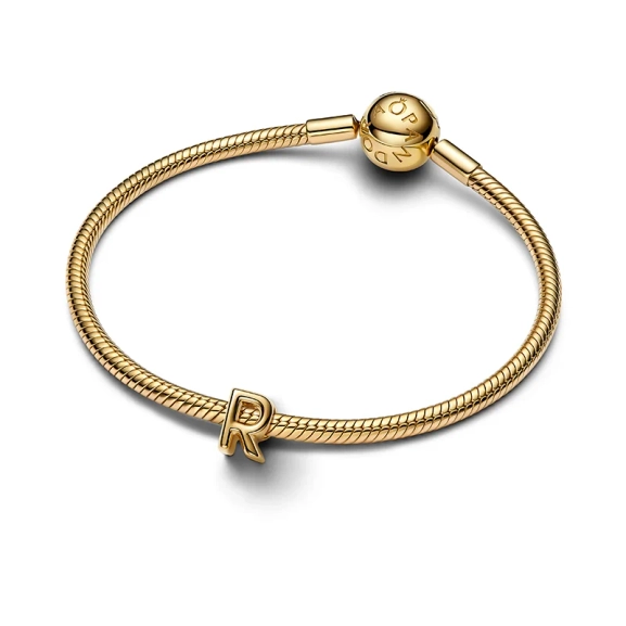 Elegant bokstavssmycke i 14 karat guldpläterad metall från Pandora. Rundad design för exklusiv och stilmedveten känsla. Lägg till personlig prägel och visa din unika personlighet med bokstaven R berlock guld.