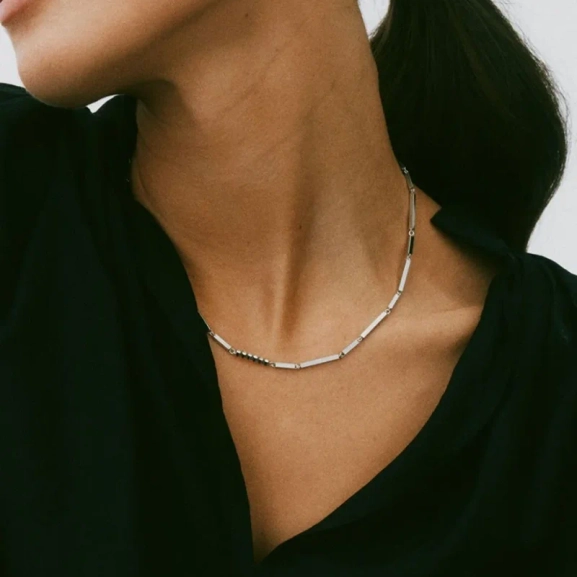 Elegant halsband i polerat stål med arkitektoniska stavar och sex gnistrande cubic zirconia-stenar