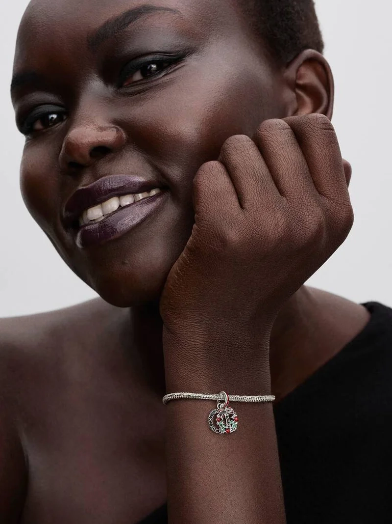 Julkrans Hängberlock från Pandora. Smyckad med gröna kristaller och röd emalj för en lekfull julstil. Lys upp dina festkläder med glamour och sprid julstämning vart du än går.