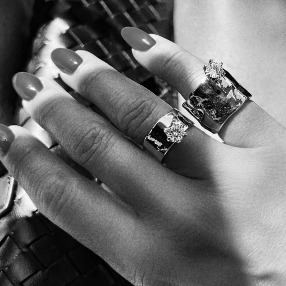 bred ring i silver med organisk yta och cubic zirconia-sten framtill.