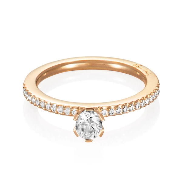 smal ring i 18K gult guld med en större briljantslipad diamant och mindre pavédiamanter på skenan.