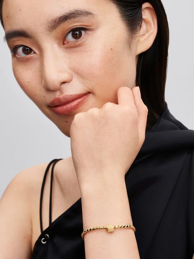 tillverkad av 14 karat guldplätering och skimrande diamanter. Låt den påminna dig om din oändliga styrka och glans.