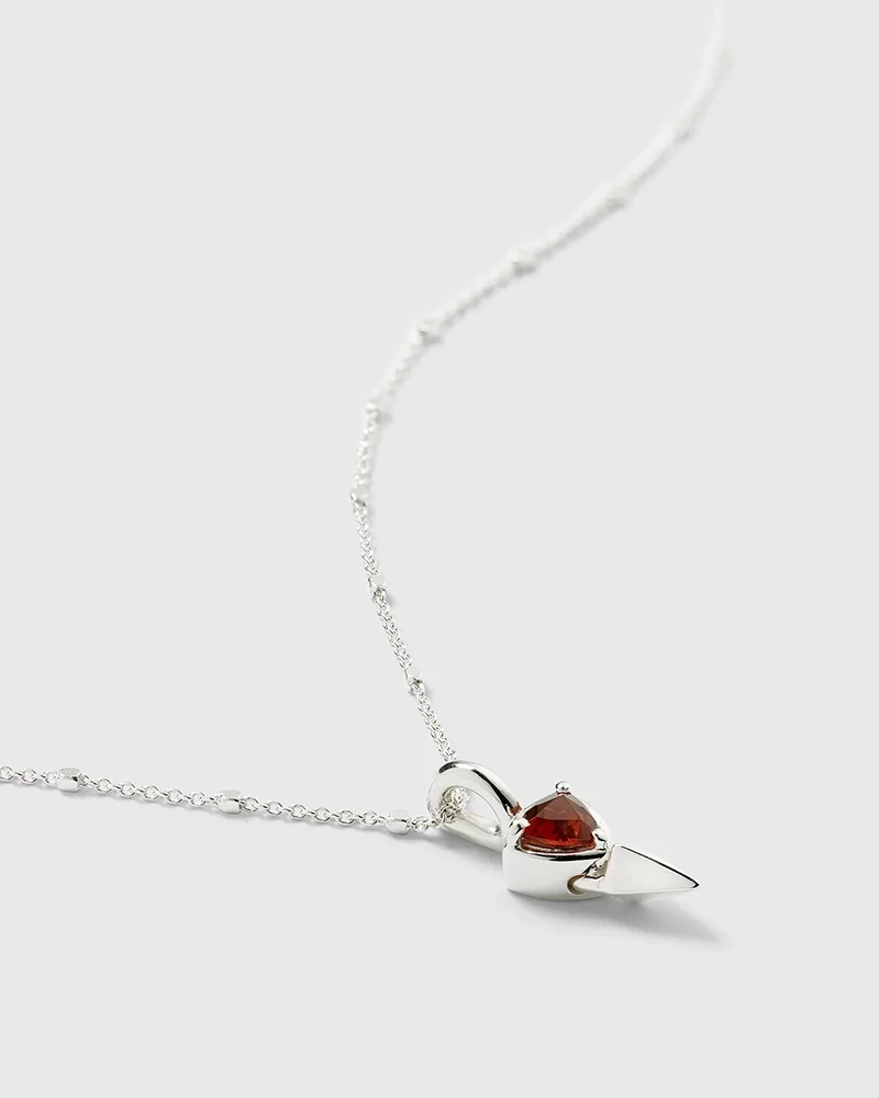 kort silverhalsband med unik kedja och spetsig hängsmycke med triangulär granat