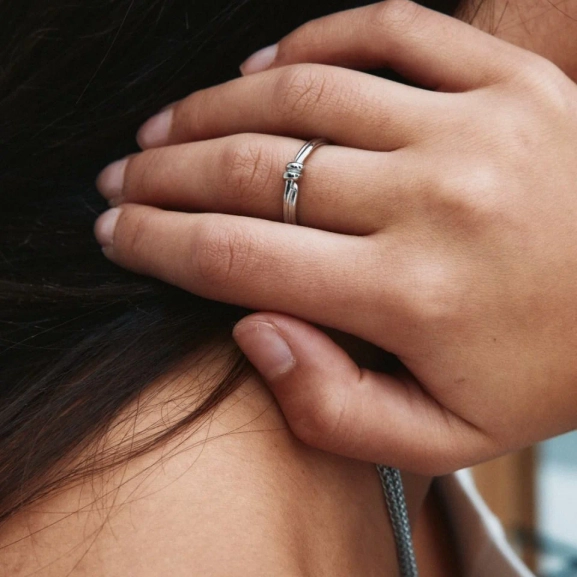 Ring i polerat rostfritt stål med spiralform och oval pärlemorpärla i centrum