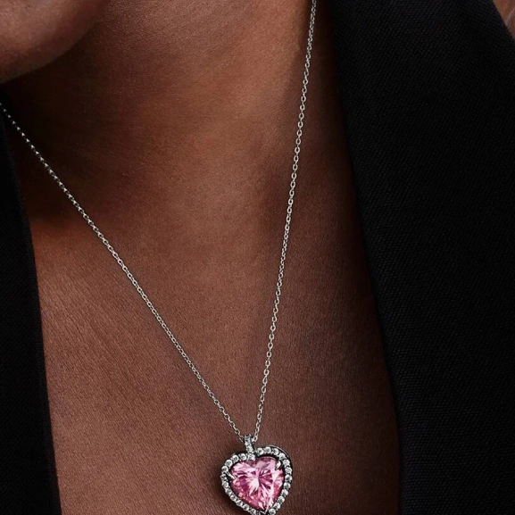 Rosa Sten Collierhalsband från Pandora. Ett hjärta av rosa kubisk zirkonia omringat av gnistrande stenar bildar en strålande cirkel som dansar längs kedjan och fångar ljuset i varje steg. Ett smycke som utstrålar elegans och romantik.