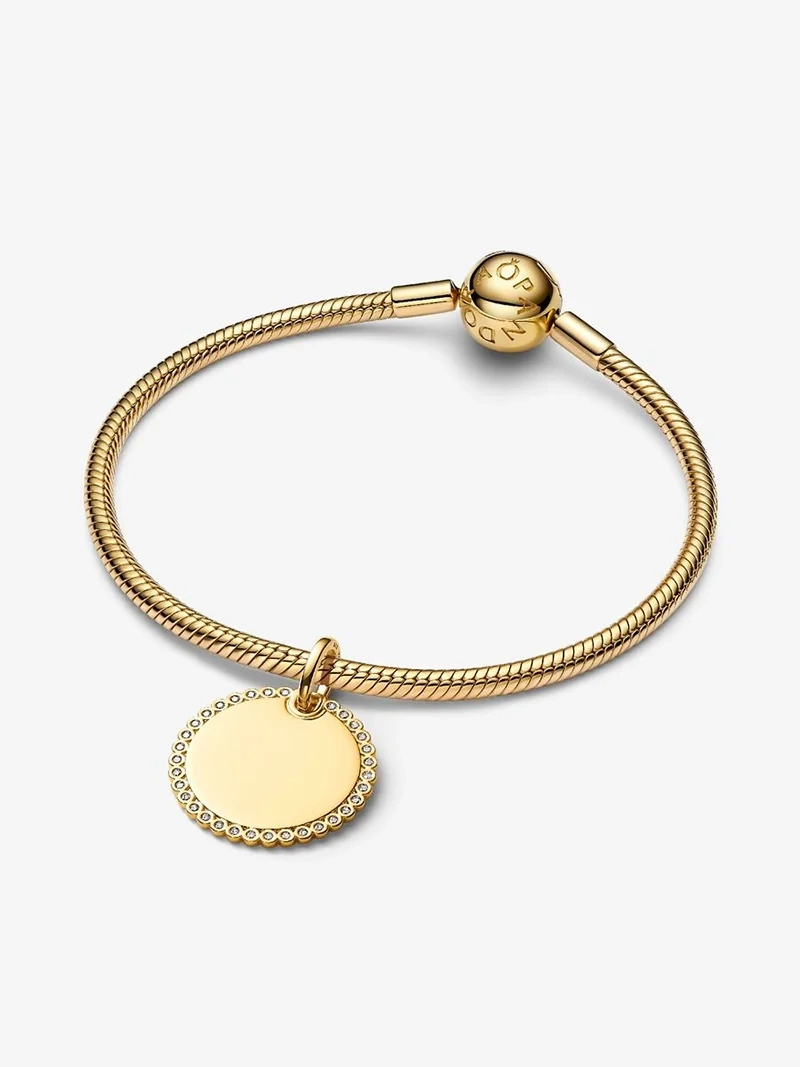 Elegant hängsmycke från Pandora med 14 karat guldplätering och gnistrande stenar. Låt detta Rund Glittrande Bricka Hängsmycke Guld bli en del av din signaturstil för extra glamour och lyxig touch.