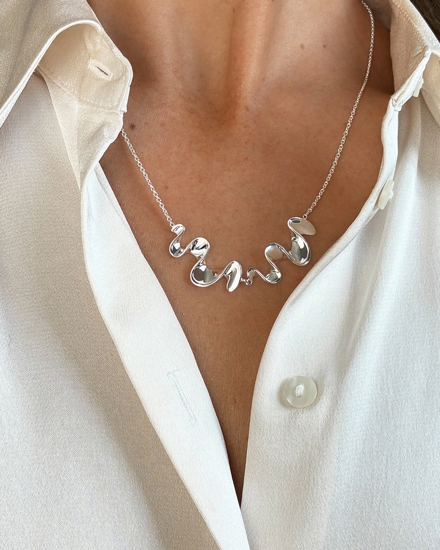 skulpturalt halsband med organisk och tidlös design.