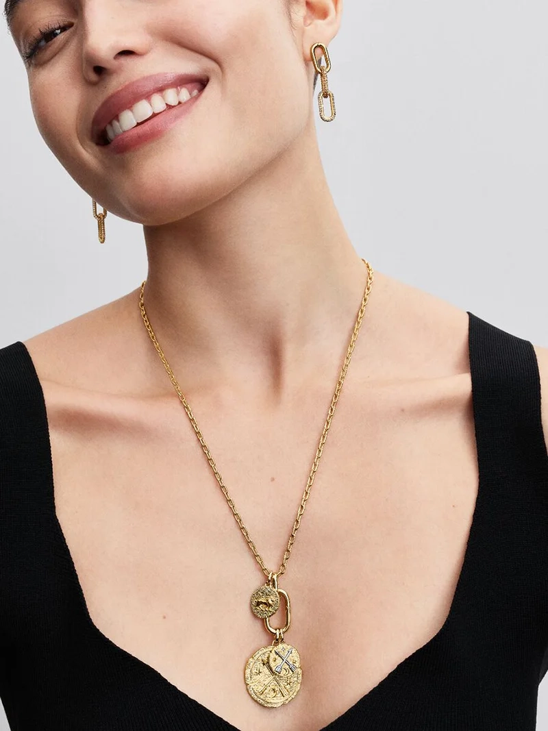 Medaljong Lejon Berlock Guld från Pandora ME med lejonmotiv och latinsk inskription "VITA VERITAS VIRTUS". En symbol för styrka och karaktär.