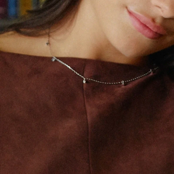 med ett elegant tärningshänge i rostfritt stål på en tunn kedja. Perfekt för en stilren och modern look.