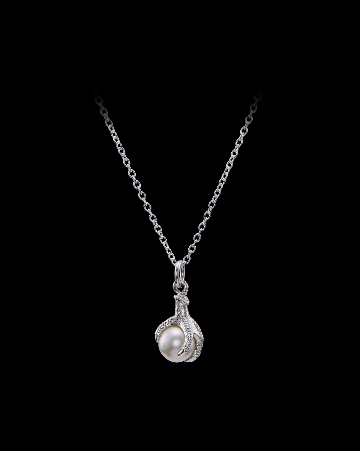Eine von Maria Nilsdotter entworfene Krallenperlenkette aus Silber mit einer Süßwasserperle wird vor einem neutralen Hintergrund gezeigt.