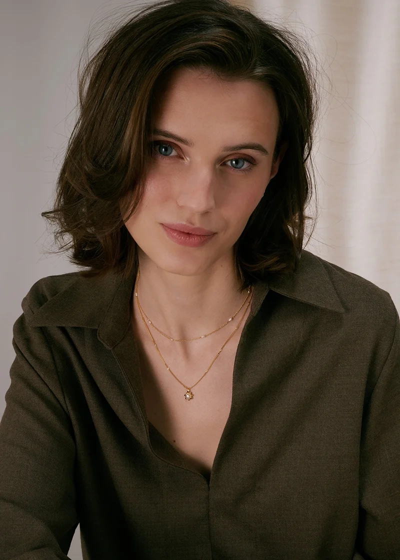 kierretyllä ketjulla ja makeanvedenhelmellä koristellulla kukalla.