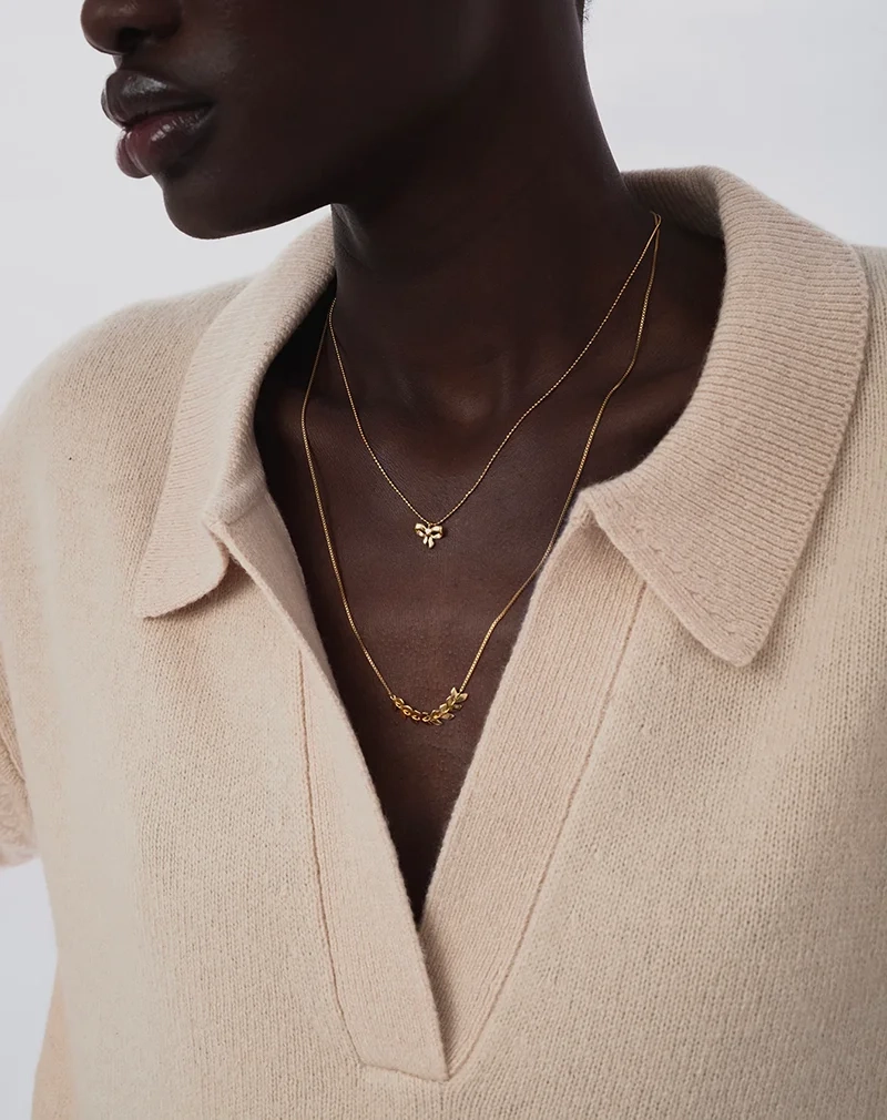 ett elegant halsband i 18K guldpläterat silver med rosettberlock och gnistrande kedja.