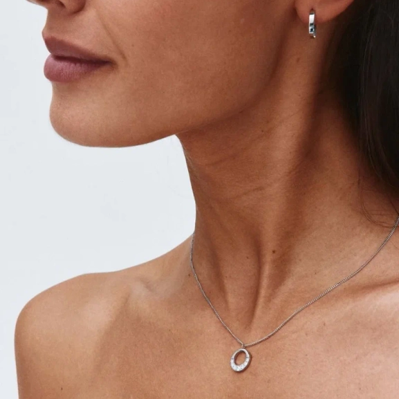 Halsband i polerat stål med runt hänge dekorerat med skimrande cubic zirconia-stenar från Edblads Monarch-kollektion.