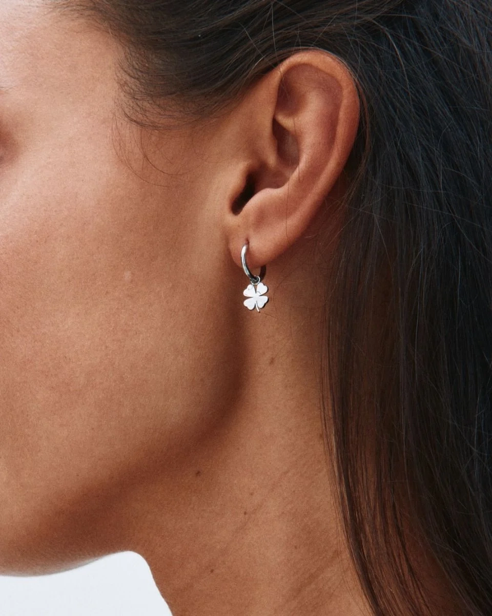 Örhängen i polerat rostfritt stål med stilren ring och avtagbart hänge format som en fyrklöver.