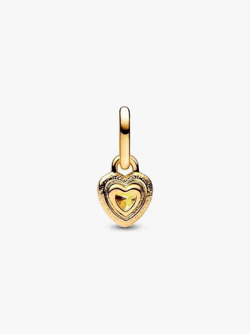 Hjärtformad minihängberlock i guld med gnistrande cubic zirconia i mitten. Symbol för innersta kärlek och passion. Pandora ME kollektion.