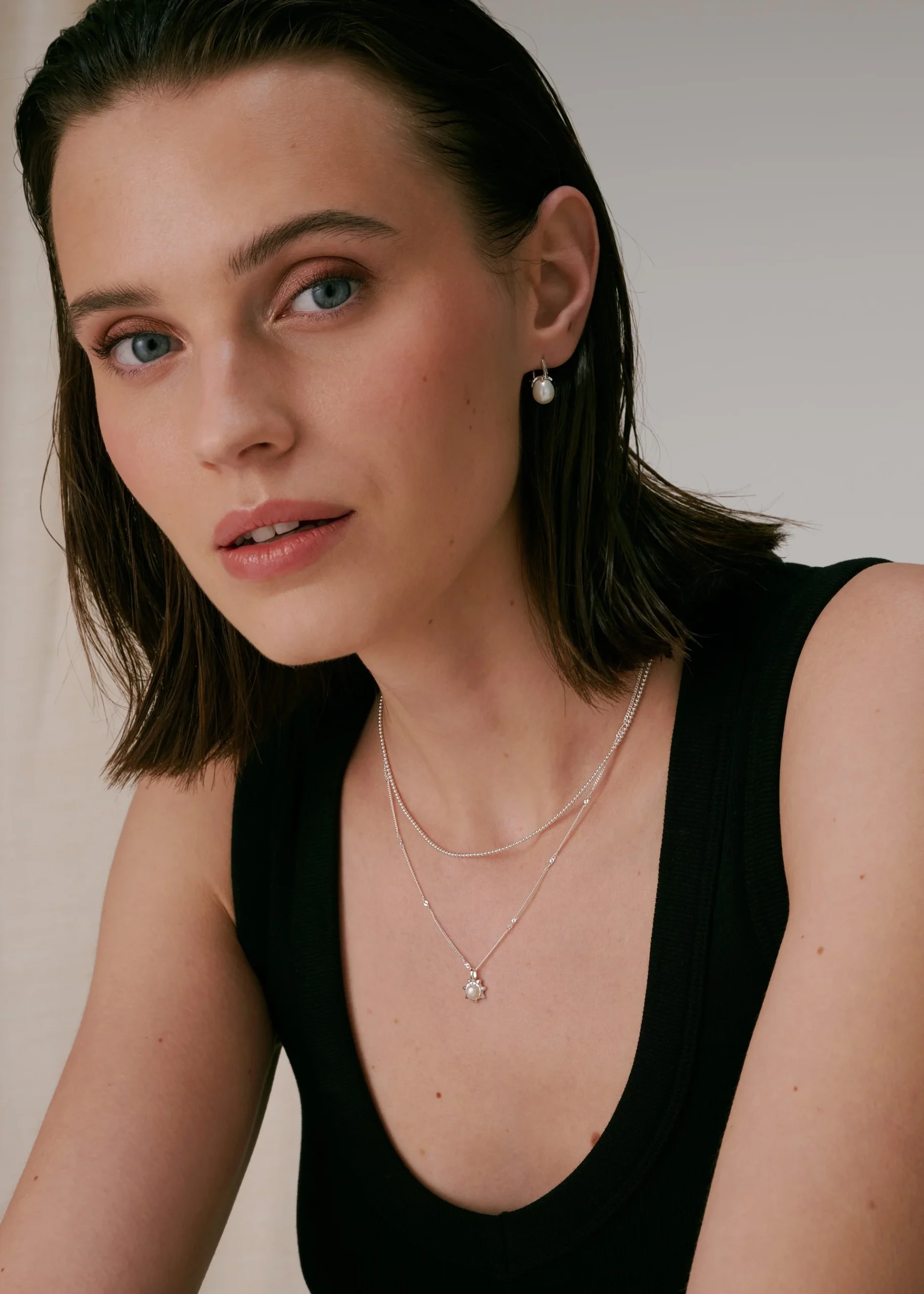 kukanmuotoinen riipus ja makeanvedenhelmi.