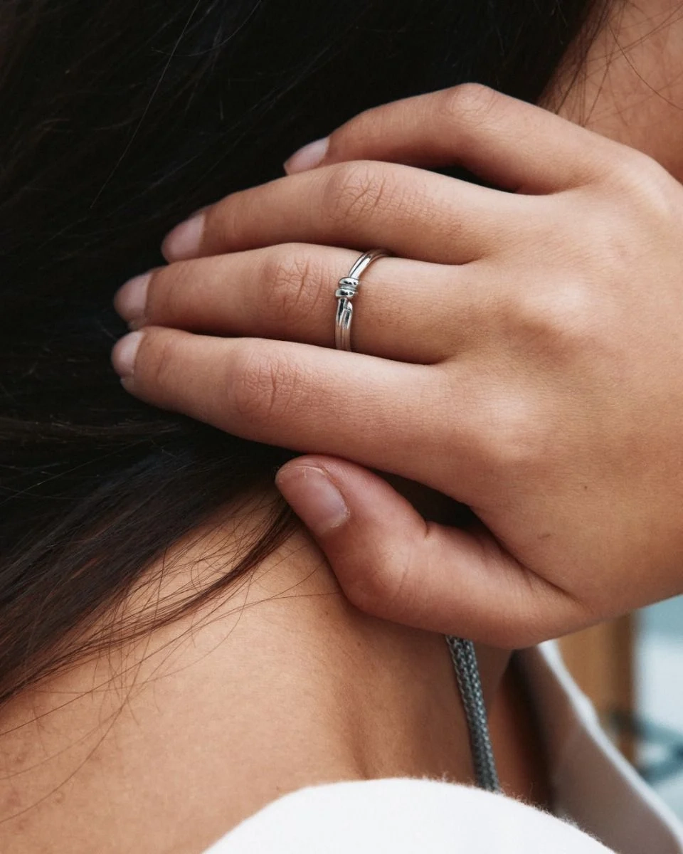 Ring i polerat rostfritt stål med spiralform och oval pärlemorpärla i centrum