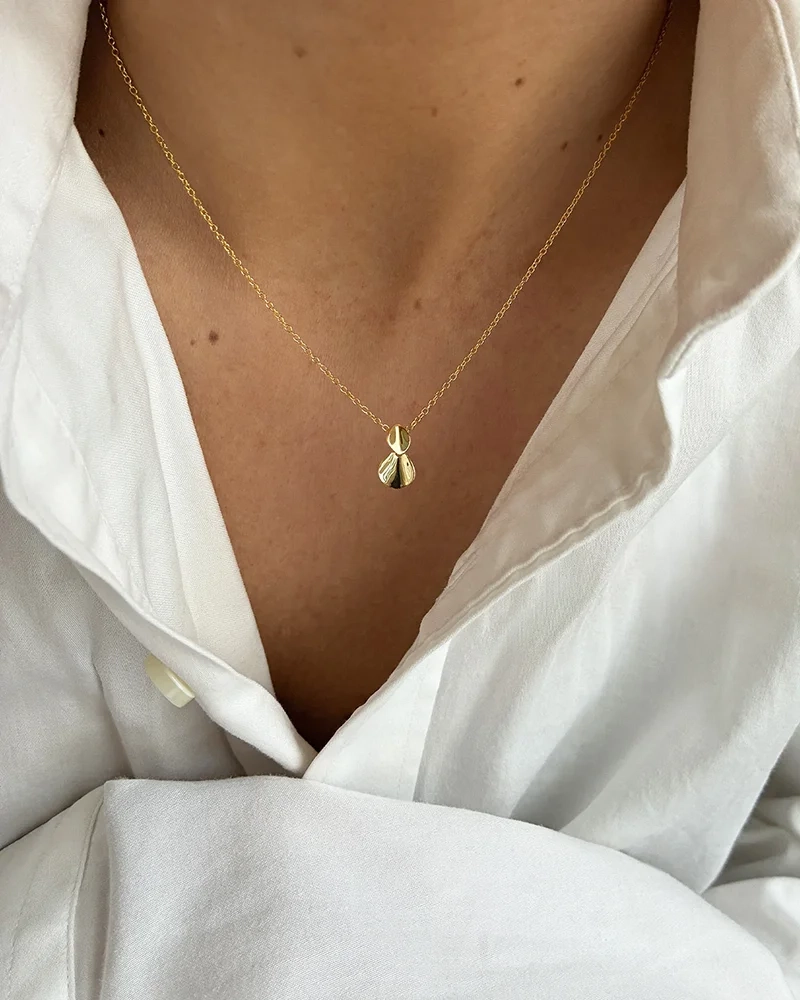 halsband i 18K guld med droppformad detalj och blanka ytor