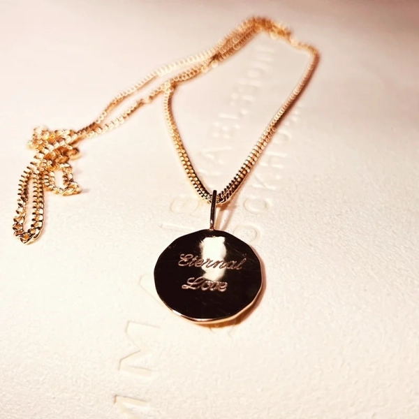Eternal Love Coin Gold halsband med rund hänge i 18K guldförgylld mässing och graverad text "Eternal Love" från Emma Israelsson.