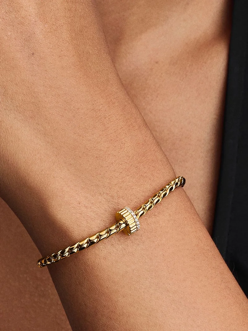 Elegant clipberlock i guld med kubisk zirkonia-stenar för en sofistikerad och säker look från Pandora Moments.