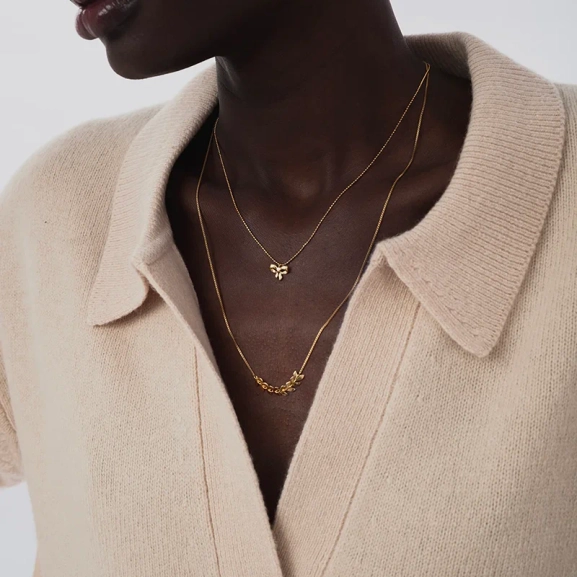 ett elegant halsband i 18K guldpläterat silver med rosettberlock och gnistrande kedja.