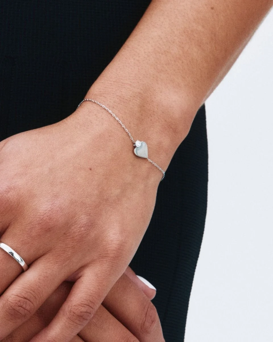 Armband i blankt rostfritt stål med stiliserat hjärta och gnistrande sten på fasettslipad ankarkedja.