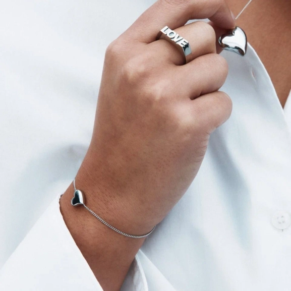 Armband i blankt rostfritt stål med hjärtformat smycke centrerat på kedjan