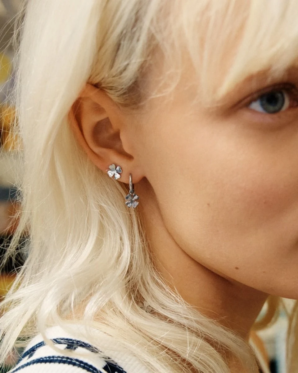 Örhängen i polerat rostfritt stål med stilren ring och avtagbart hänge format som en fyrklöver.