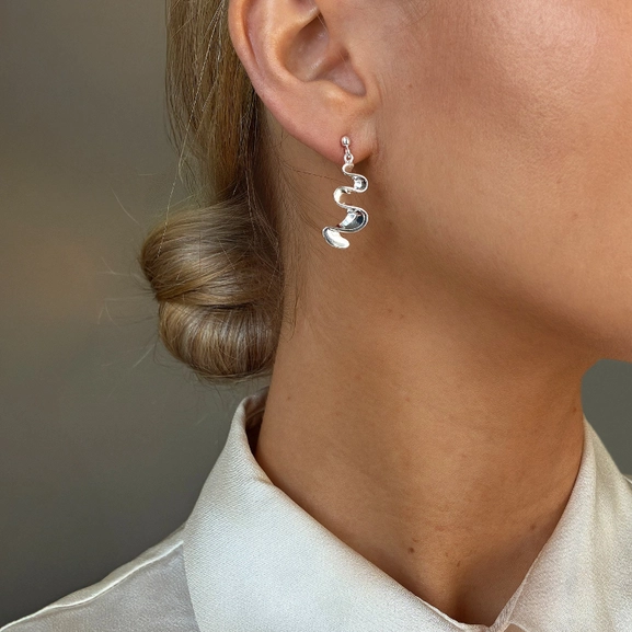 polerade silverörhängen med skulptural