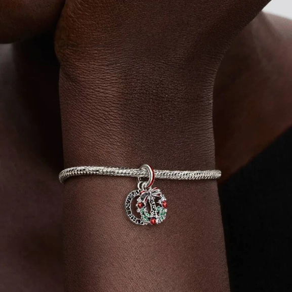 Julkrans Hängberlock från Pandora. Smyckad med gröna kristaller och röd emalj för en lekfull julstil. Lys upp dina festkläder med glamour och sprid julstämning vart du än går.