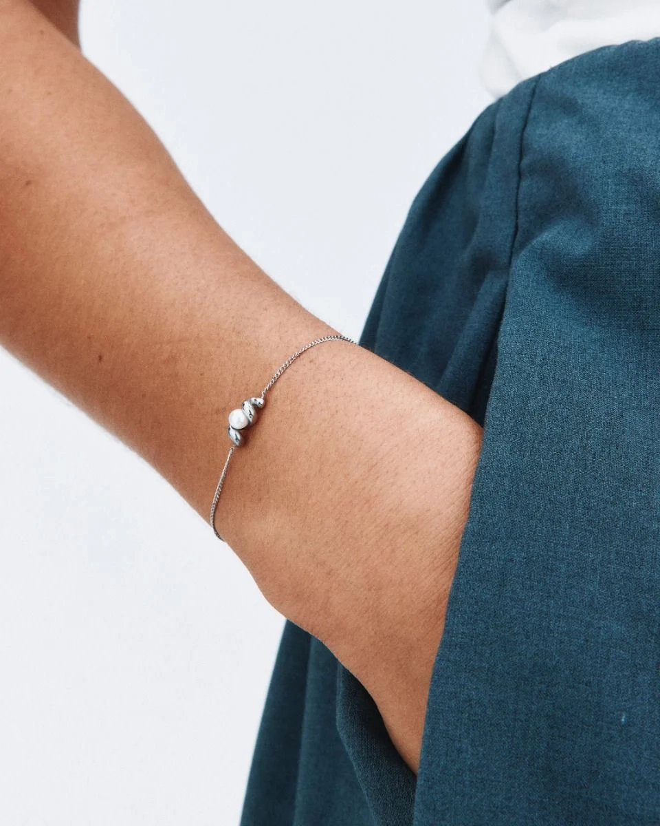 Armband i polerat stål med tvinnad design och skimrande pärlemorpärla på klassisk pansarkedja från Edblad.