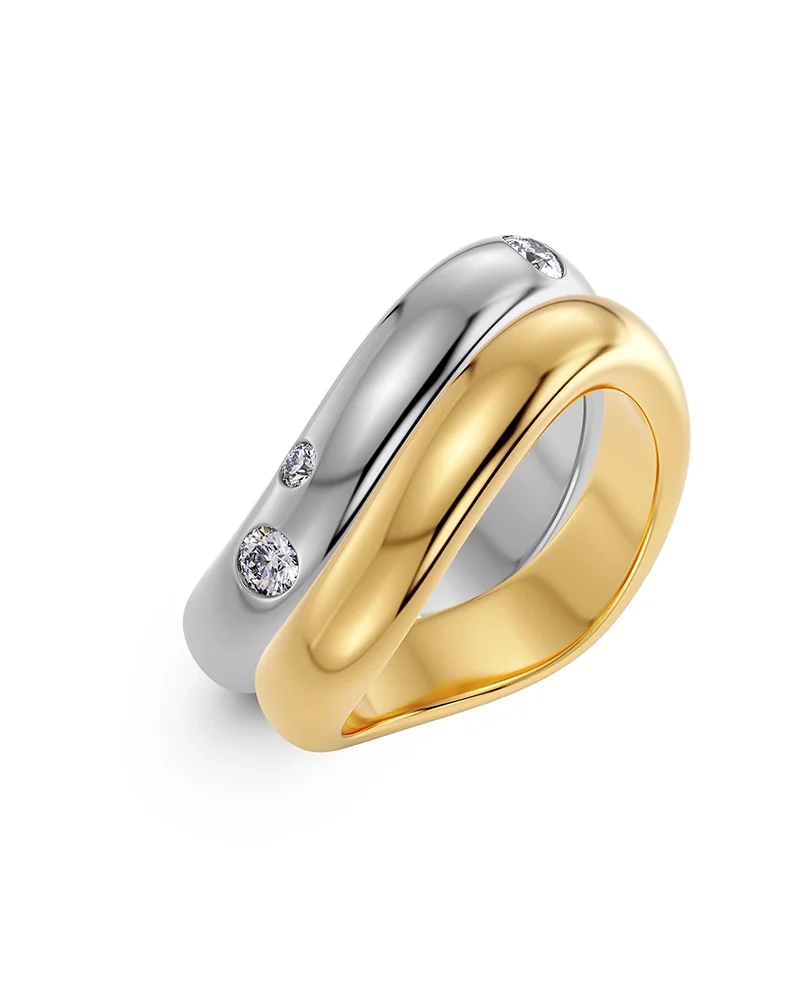 Två Selena ringar i stål och guld med vågformade skenor; en med cubic zirconia-stenar och en slät