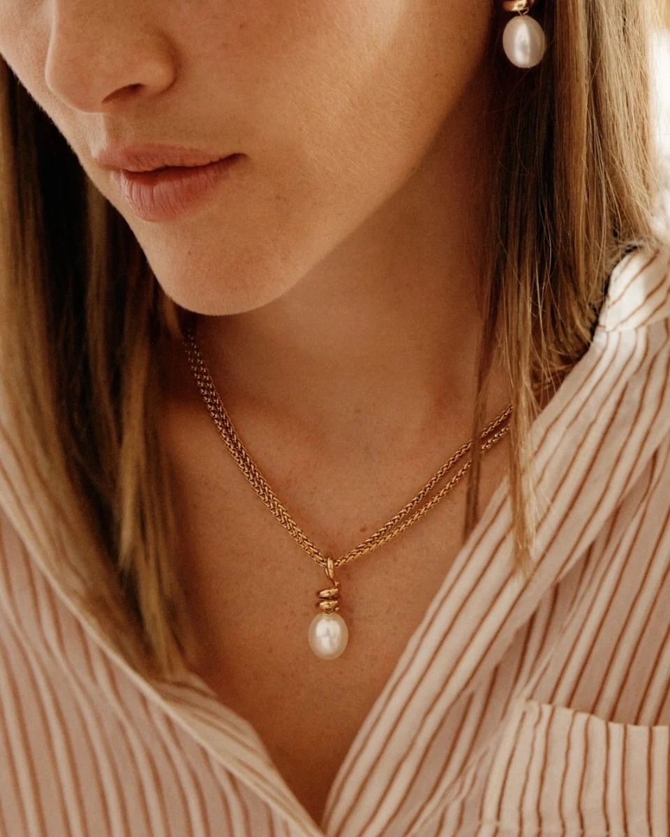 Halsband i 14K guldplätering med spiralformad charm och oval pärlemorpärla från Edblad