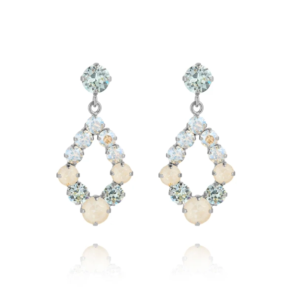Droppformade örhängen i rhodiumpläterad mässing med Swarovski-kristaller i blå toner från Caroline Svedbom.