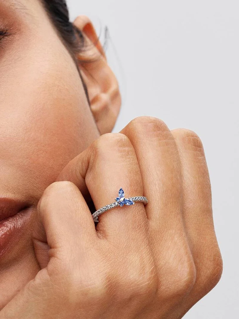 Blå och klara kubiska zirkoniastenar gnistrar på denna Pandora Timeless ring med en förtrollande fjärilssymbol i sterlingsilver.