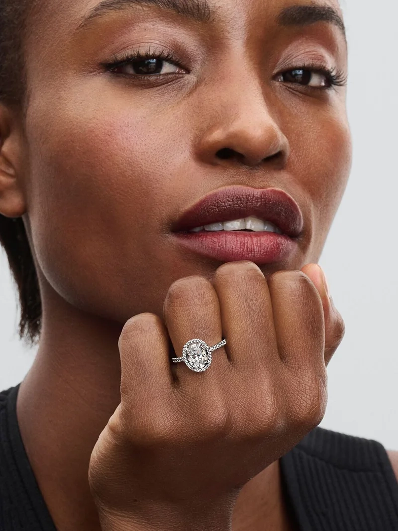 Pandora Timeless Oval Glittrande Halo Statementring i sterlingsilver med stor sten i mitten och strålande kant av små stenar. Perfekt för extra touch av glamour och att kombinera med andra smycken.