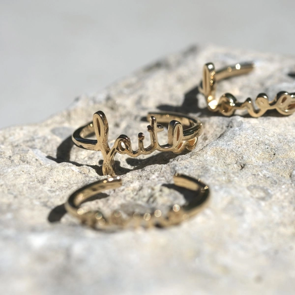 justerbar ring i 18K guldförgylld mässing med "faith" i handskrivet typsnitt. Artikelnummer: ring181.