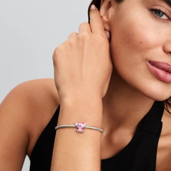 Disney Lilo & Stitch änglaberlock från Pandora i glänsande sterlingsilver med lila och rosa emalj. En lekfullt elegant tillskott till din smyckessamling