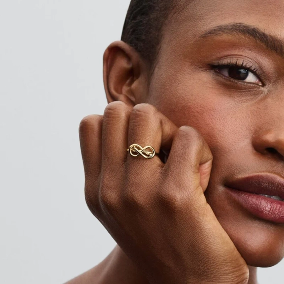 Förgylld ring med evighetsknut och gnistrande stenar från Pandora Moments kollektionen. En symbol för evig kärlek och harmoni