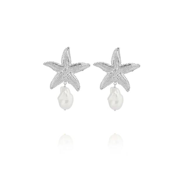 Sjöstjärneformade örhängen i rodiumpläterad mässing med Swarovski-kristaller och hängande pärla från Caroline Svedbom.