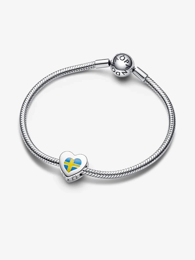 Hjärtformad berlock med svenska flaggans färger och städer ingraverade. Tillverkad i sterlingsilver och emalj. En symbol för passion för Sverige och dess kulturarv.