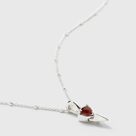 kort silverhalsband med unik kedja och spetsig hängsmycke med triangulär granat